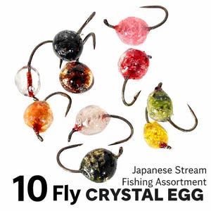 Puede incluir: Un surtido de 10 moscas de pesca de huevo de cristal en varios colores, incluyendo transparente, naranja, rojo, rosa, amarillo y negro. Cada mosca tiene un anzuelo curvo. El texto en la imagen dice "10 Fly CRYSTAL EGG" y "Japanese Stream Fishing Assortment."