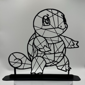 May include: A black metal sculpture of a Squirtle, a Pokémon character. The artwork is constructed from interconnected lines, forming a geometric pattern. It rests on a black rectangular base, set against a white backdrop.