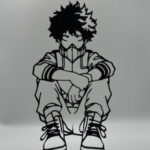 May include: A monochrome metal cutout depicting a seated anime character with spiky hair and a face mask. The figure wears a jacket, trousers, and trainers, and is mounted on a black rectangular base. The character's arms are crossed.