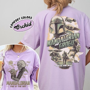 Peut inclure: T-shirt de couleur orchid&eacute;e avec des graphismes de la s&eacute;rie "The Mandalorian". L'avant pr&eacute;sente le Mandalorien et Grogu, tandis que l'arri&egrave;re affiche un design plus grand avec le texte "The Mandalorian and Grogu" et "This is the Way."