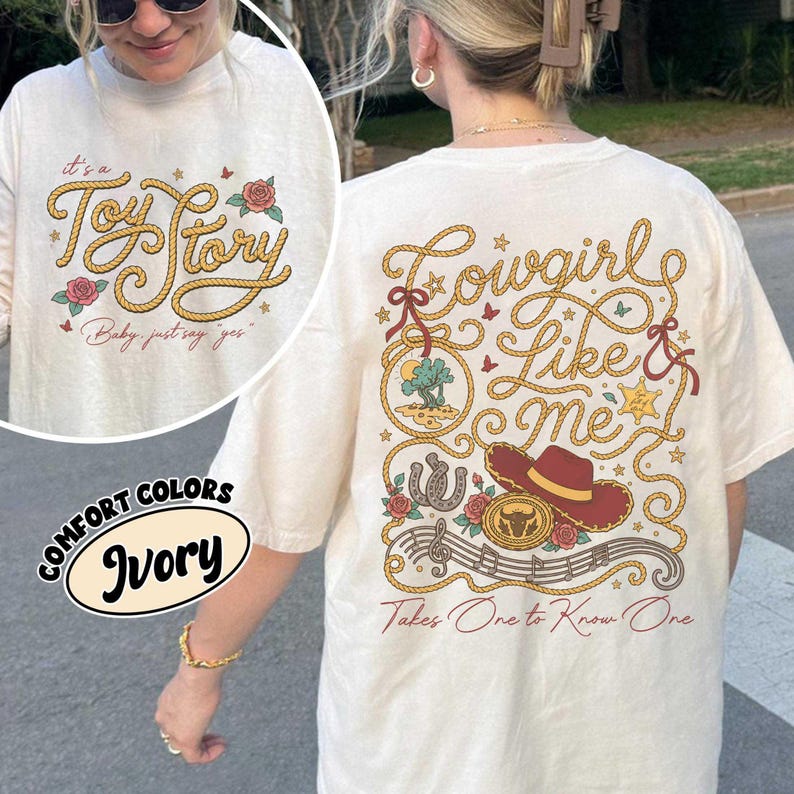 Puede incluir: Una camiseta color marfil con un dise&ntilde;o gr&aacute;fico. El frente muestra el texto 'it's a Toy Story' y 'Baby, just say yes' con letras de cuerda y rosas. La parte posterior muestra 'Cowgirl Like me' y 'Takes One to Know One' con cuerda, un sombrero y notas.