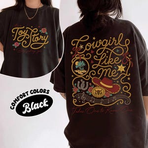 Puede incluir: Una camiseta negra con un gr&aacute;fico frontal con el texto Toy Story y rosas, y un gr&aacute;fico trasero con el texto Cowgirl Like Me, un sombrero de vaquero rojo, una herradura, una hebilla de cintur&oacute;n, notas musicales y letras amarillas y rojas.