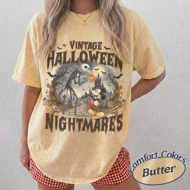 Puede incluir: Una camiseta amarilla de manga corta con un estampado gr&aacute;fico que incluye el texto VINTAGE HALLOWEEN NIGHTMARES. El dise&ntilde;o muestra una figura esquel&eacute;tica y un rat&oacute;n de dibujos animados en un bosque oscuro con murci&eacute;lagos y una luna.