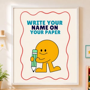Può includere: Una stampa artistica incorniciata con sfondo color crema e bordo rosso ondulato. Il testo recita WRITE YOUR NAME ON YOUR PAPER in blu e nero. Sotto il testo c'è un personaggio circolare giallo che tiene in mano una matita verde con punta nera.