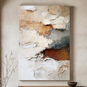 Op de afbeelding: Grote abstracte getextureerde muurkunst in neutrale tinten wit, bruin en grijs. Het kunstwerk wordt tentoongesteld in een lichte kamer met een houten bank en decoratieve kommen. De kamer heeft een natuurlijke, minimalistische esthetiek.