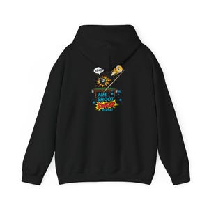 Puede incluir: Sudadera con capucha negra con un gráfico colorido de una mesa de billar, un taco y una bola ocho. El gráfico incluye el texto "AIM SHOOT SWEAR REPEAT". La sudadera tiene capucha y mangas largas.