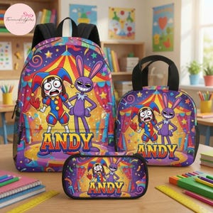 May include: A backpack, a lunch bag, and a pencil case featuring a circus tent background with a jester character and a purple rabbit character. The name ANDY is printed in large yellow letters on each item. The set has a colorful design.