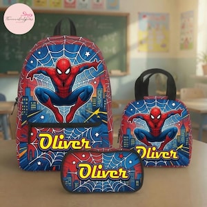 May include: A backpack, a lunch bag, and a pencil case set featuring a red and blue Spider-Man graphic over a spiderweb and city skyline pattern. Each item displays the name Oliver in yellow lettering with a black outline against the blue web.