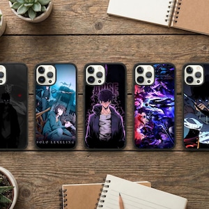 Op de afbeelding: Vijf telefoonhoesjes met unieke ontwerpen met anime-personages. De zwarte hoesjes tonen verschillende kleurrijke illustraties, waaronder een figuur in een donkere mantel, een groep personages in een blauwe omgeving en een personage met paarse energie.
