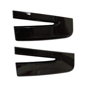 以下が含まれることがあります： 光沢のある黒色の自動車用トリムピースが2つ。各ピースは、湾曲したエッジと切り欠きを備えたユニークな形状をしています。これらのピースは、車両に取り付けて外観を向上させるように設計されています。