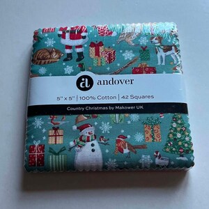 May include: A stack of 42 square cotton fabric pieces, each measuring 12.7 cm x 12.7 cm, wrapped in plastic. The teal fabric features a Christmas pattern with Santa, a snowman, gifts, a dog, a cat, and snowflakes. The label reads: andover, 5" x 5" | 100% Cotton | 42 Squares, Country Christmas by Makower UK.
