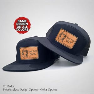 May include: Two black baseball caps with a leather patch featuring an image of Benjamin Franklin and the text "TAX THIS DICK". The caps have a flat brim and a mesh back.