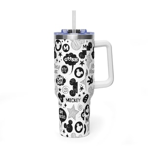 May include: A white tumbler with a black and white Mickey Mouse themed design. The tumbler has a white handle and a blue lid with a white straw. The design includes Mickey Mouse silhouettes, stars, and text like "Gosh" and "Oh Boy".