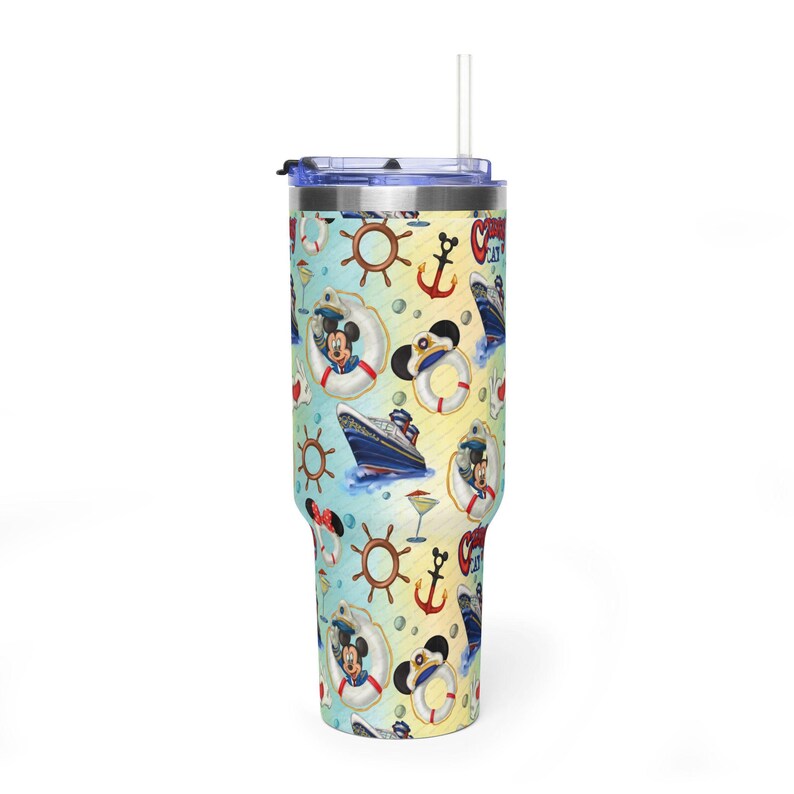May include: A tall stainless steel tumbler with a clear lid and straw, featuring a light blue and yellow background patterned with cruise ships, brown ship wheels, red anchors, life preservers, and cartoon mouse ears in sailor hats.