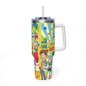 May include: An insulated tumbler with a vibrant "Toy Story" design. The tumbler has a white handle, a blue lid, and a white straw. The design features Woody, Buzz Lightyear, and other characters from the film. The tumbler is suitable for cold drinks.