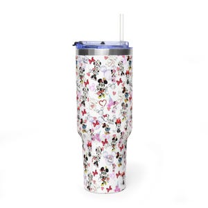 Puede incluir: Un vaso blanco con tapa azul y pajita transparente. El vaso est&aacute; cubierto con un patr&oacute;n de ilustraciones de Minnie Mouse, corazones y la Torre Eiffel. El vaso est&aacute; dise&ntilde;ado para contener aproximadamente 887 ml.