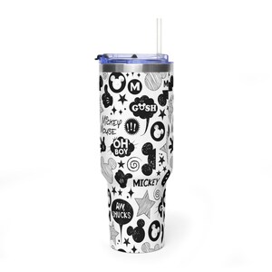May include: A white tumbler with a black and white cartoon design featuring Mickey Mouse. The tumbler has a blue lid and a clear straw. The design includes speech bubbles with phrases like "Gush" and "Aw Shucks."