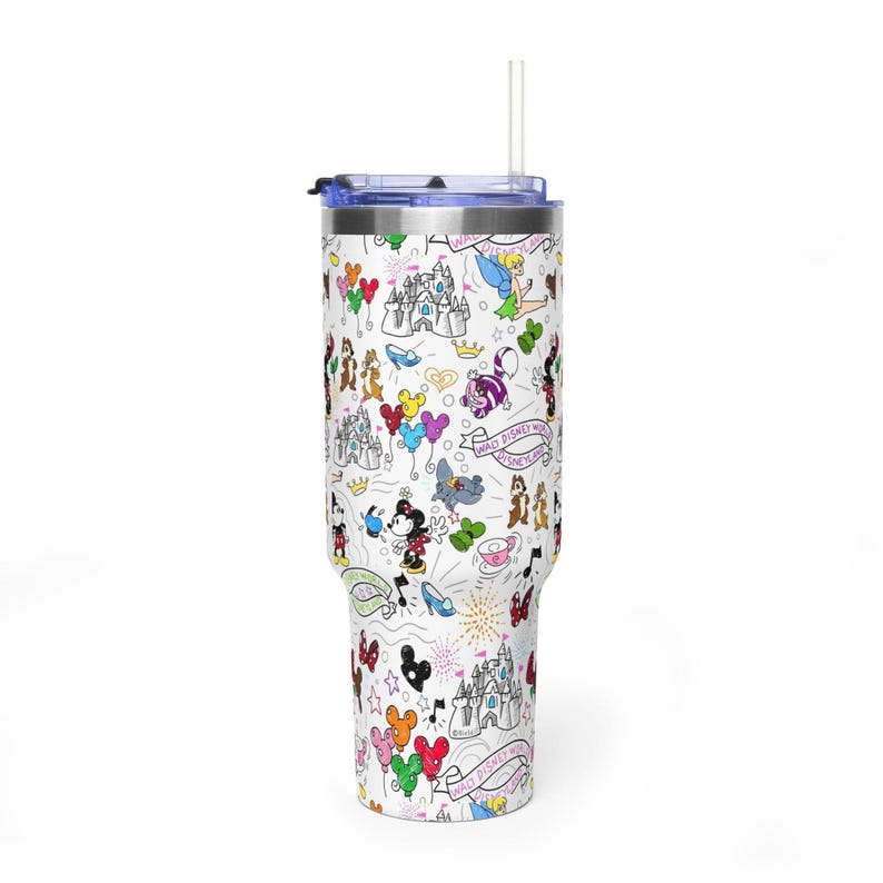 Puede incluir: Un vaso blanco con tapa y pajita azules, cubierto con un patr&oacute;n caprichoso con tem&aacute;tica de Disney. El dise&ntilde;o incluye personajes de dibujos animados, castillos, globos y las palabras "Walt Disney World" en un patr&oacute;n repetido. El vaso est&aacute; dise&ntilde;ado para contener aproximadamente 887 ml.
