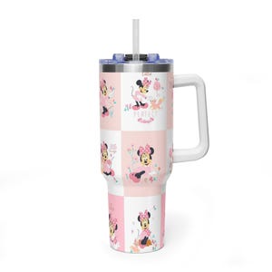 May include: A white and pink tumbler with a Minnie Mouse design. The tumbler has a handle, a lid, and a straw. The design includes Minnie Mouse in various poses with the words "Perfect" and "Big" on the tumbler.