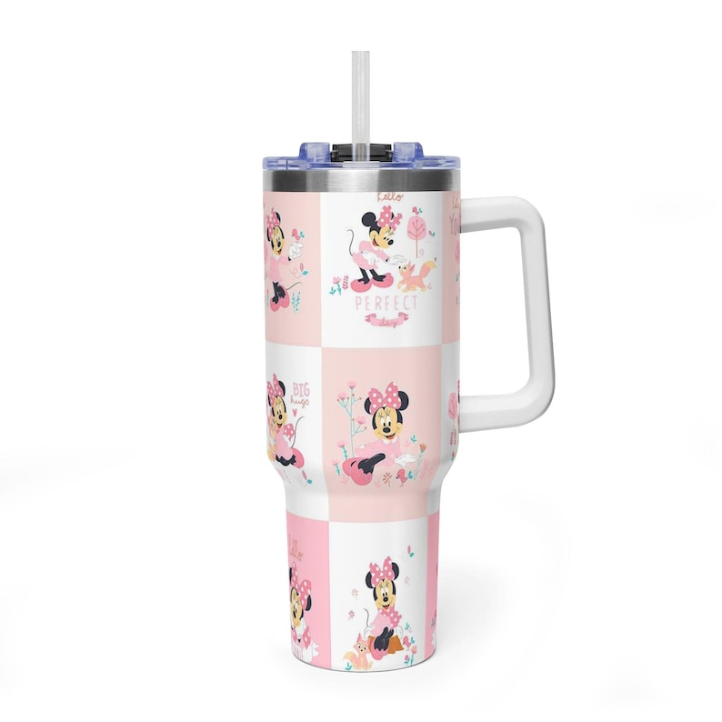 May include: A white and pink tumbler with a Minnie Mouse design. The tumbler has a handle, a lid, and a straw. The design includes Minnie Mouse in various poses with the words "Perfect" and "Big" on the tumbler.