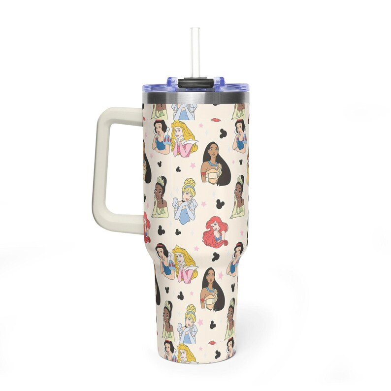 K&ouml;nnte beinhalten: Ein cremefarbener Becher mit Griff und Strohhalm, der ein sich wiederholendes Muster von Cartoon-Prinzessinnen und Mickey-Mouse-Silhouetten aufweist. Der Becher hat einen blauen Deckel und einen wei&szlig;en Griff.