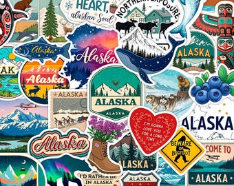 May include: A selection of vibrant Alaska-themed stickers. Designs include a whale, moose, mountains, and the text "Alaska." Other stickers feature a bear, a boot with flowers, and the phrase "Beware of Bigfoot."