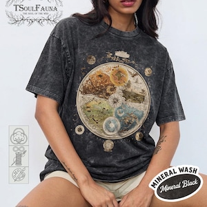 May include: A white ceramic mug with a black handle and the text "But First, Coffee" in a bold, black font. The mug is filled with a dark liquid, likely coffee, and sits on a light-colored surface.