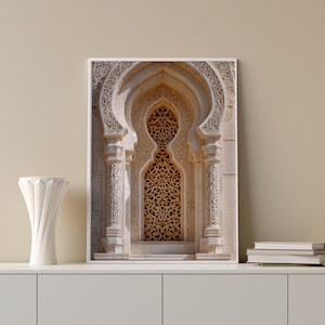 May include: A framed print of an ornate architectural window with intricate carvings. The window features a central arched opening with a latticework design, flanked by decorative columns. The color palette is primarily beige and cream.