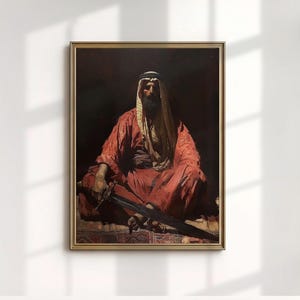 Puede incluir: Una impresión enmarcada de una pintura al óleo que representa una figura sentada con túnicas rojas y un tocado. La figura sostiene una espada y el fondo es oscuro. El marco es dorado.
