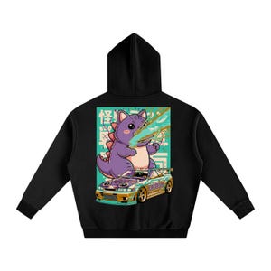 May include: Black hoodie with a graphic on the back. The graphic shows a purple cartoon dinosaur and a car. The dinosaur is breathing money. The car has the word "CATZILLA" on it.