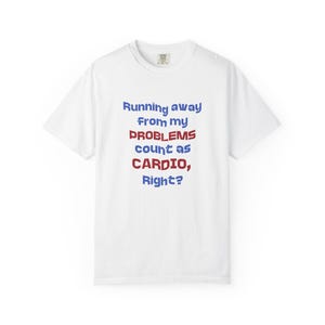 Może przedstawiać: Biały t-shirt z krótkim rękawem z niebiesko-czerwonym napisem: Running away from my PROBLEMS count as CARDIO, Right? Koszulka ma okrągły dekolt i standardowy krój, a nadruk znajduje się wyraźnie na środku klatki piersiowej.