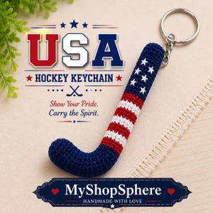 May include: A crochet hockey stick keychain featuring a red, white, and blue American flag pattern with white stars on a dark blue background. The text USA HOCKEY KEYCHAIN, Show Your Pride. Carry the Spirit. and MyShopSphere are visible.