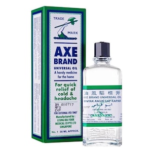 Puede incluir: Botella y caja de Aceite Universal Axe Brand. La caja es verde y blanca con el texto "Axe Brand Universal Oil" y "Para el alivio rápido del resfriado y el dolor de cabeza". La botella es transparente con tapa negra.