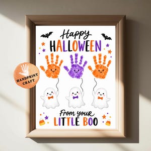 Może przedstawiać: Oprawiony wydruk na Halloween z napisem Happy Halloween oraz From your little boo. Projekt zawiera trzy duszki wykonane z odcisków dłoni w kolorze pomarańczowym i fioletowym, połączone sznurkiem z białymi duszkami w muszkach oraz motywami nietoperzy.