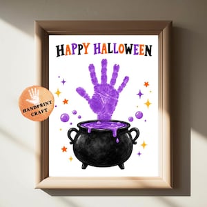 May include: A framed print featuring the text HAPPY HALLOWEEN in black and orange letters above a purple handprint emerging from a black cauldron. The design includes small purple bubbles and orange and purple stars on a white background.