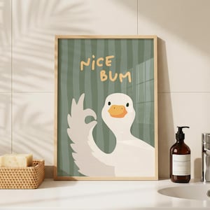 Op de afbeelding: Een rechthoekige wandkunstprint met een witte gans op een saliegroene achtergrond met verticale strepen. De gans maakt een oké-gebaar met zijn vleugel. De tekst NICE BUM staat in een vet, lichtgeel, handgetekend lettertype erboven.