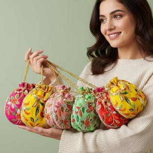 Könnte beinhalten: Eine Sammlung von sechs farbenfrohen, bestickten Beuteln mit Kordelzug. Jede Tasche hat ein einzigartiges Blumendesign in Rosa, Gelb, Grün und Rot. Die Taschen haben goldene Kettenriemen und werden zusammengehalten.