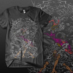 May include: Dark grey t-shirt with a detailed graphic of a character in a dynamic pose, surrounded by intricate, stylised elements. The design incorporates shades of grey, purple, and red, creating a striking visual contrast. The overall theme is anime.