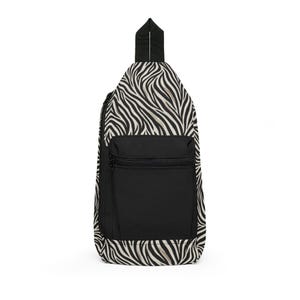 Könnte beinhalten: Eine Sling-Tasche mit schwarz-weißem Zebra-Print, einer schwarzen Vordertasche und einem Reißverschluss. Die Tasche hat einen schwarzen Riemen und einen oberen Griff. Die Tasche ist zum Tragen über einer Schulter konzipiert.
