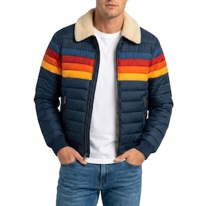 Könnte beinhalten: Marineblaue Steppjacke mit cremefarbenem Shearling-Kragen und farbenfrohem Streifendesign auf der Brust. Die Jacke hat einen Reißverschluss und zwei Vordertaschen. Die Streifen sind rot, orange und gelb.