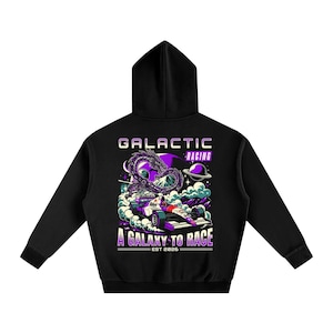 Może przedstawiać: Czarna bluza z kapturem z grafiką na plecach. Projekt przedstawia samochód wyścigowy, smoka oraz tekst "GALACTIC RACING" i "A GALAXY TO RACE". Projekt jest w odcieniach fioletu, bieli i czerni.