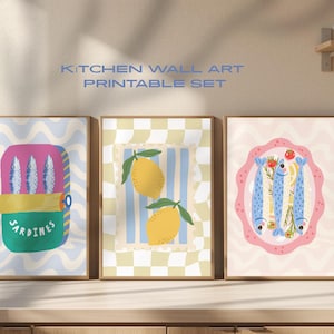 Puede incluir: Un conjunto de tres láminas enmarcadas para la pared de la cocina. Las láminas presentan ilustraciones de sardinas en lata, limones y sardinas en un plato. Las láminas tienen un estilo retro con una variedad de colores, incluyendo azul, amarillo y rosa. El texto dice: KITCHEN WALL ART PRINTABLE SET.