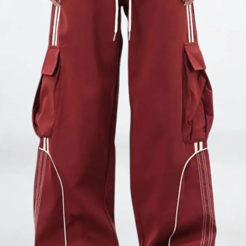 Baggy Cargo Pants | Casual Wide Leg Joggers | Modern Y2K Streetwear 

Woman wearing black baggy cargo pants with wide leg fit and side stripe detail styled for Y2K streetwear fashion.