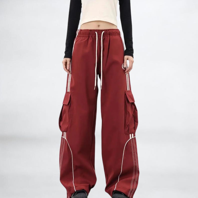 Baggy Cargo Pants | Casual Wide Leg Joggers | Modern Y2K Streetwear 

Woman wearing black baggy cargo pants with wide leg fit and side stripe detail styled for Y2K streetwear fashion.