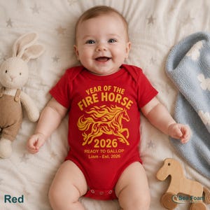 May include: A red short-sleeved baby bodysuit featuring a yellow graphic of a horse made of flames. The text reads: YEAR OF THE FIRE HORSE 2026 READY TO GALLOP Liam - Est. 2026. The garment has a round neckline and snap closures at the bottom.