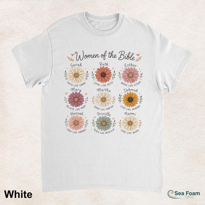 May include: White t-shirt featuring the text "Women of the Bible" above floral illustrations with names like Sarah, Ruth, and Esther. Each flower has a corresponding inspirational phrase. The shirt is made of a soft material.