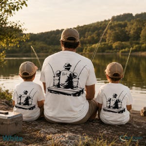 May include: White t-shirts with a black graphic of a person fishing with two children. The graphic includes the text "Robert" and "Lucas" and "James". The shirts are worn by a person and two children fishing by a lake.