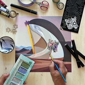 Op de afbeelding: Een vierkante kunstdruk met een gestileerd landschap met een grote, gebogen, wit en donkergrijze structuur, een gouden verticaal accent en een bloemrijke vlinderillustratie. De print is omringd door kunstbenodigdheden zoals verf en stiften.