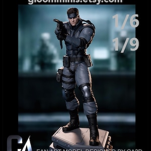 Pode incluir: Uma figura de Solid Snake em traje tático cinzento com botas, luvas e joelheiras pretas, segurando uma pistola. A base é uma plataforma cinzenta. O texto inclui gloomminis.etsy.com, 1/6, 1/9, FAN ART MODEL DESIGNED BY CA3D e o logótipo CA.