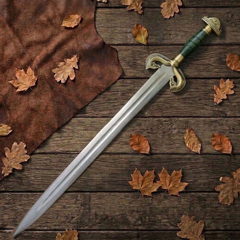 Peut inclure: Une &eacute;p&eacute;e longue dot&eacute;e d'une lame en acier &agrave; double tranchant, d'une poign&eacute;e cylindrique vert fonc&eacute; et d'une garde en laiton orn&eacute;e de quillons incurv&eacute;s en forme de volutes. Le pommeau est un capuchon en laiton arrondi avec un motif textur&eacute;.